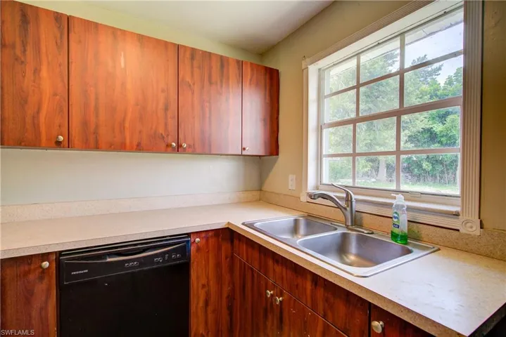 Kitchen with black dishwasher and light countertops