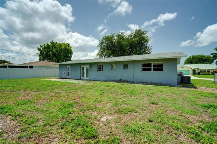 Rear view of house with french doors, stucco siding, and a patio area