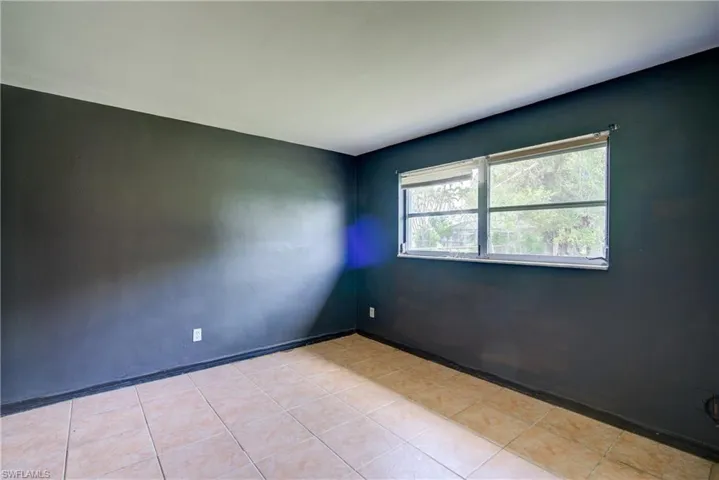 Unfurnished room with light tile patterned floors and baseboards