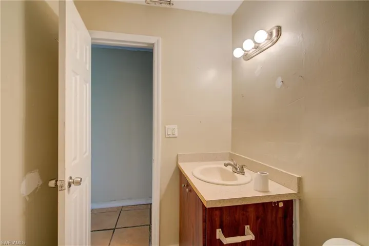 Half bath featuring vanity and light tile patterned flooring