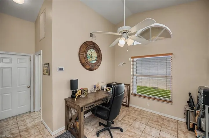 Vaulted ceiling space featuring ceramic tile flooring and a multi-panel interior door