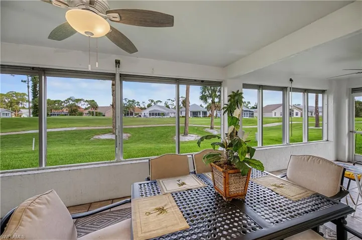 Screened patio with tile flooring and ceiling fan