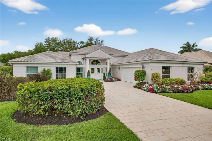 View of front of house with stucco siding, a garage, driveway, and a tile roof