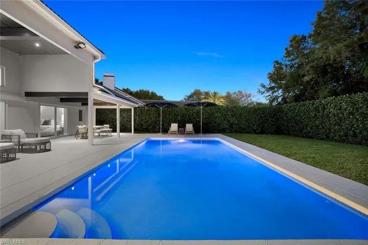 View of swimming pool with patio surround, a fenced backyard, and outdoor dining area
