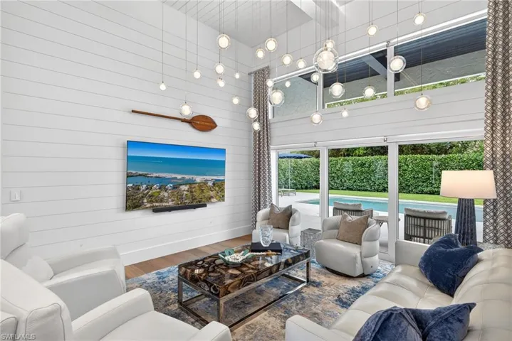 Living room with wood finished floors, a high ceiling, and wood walls