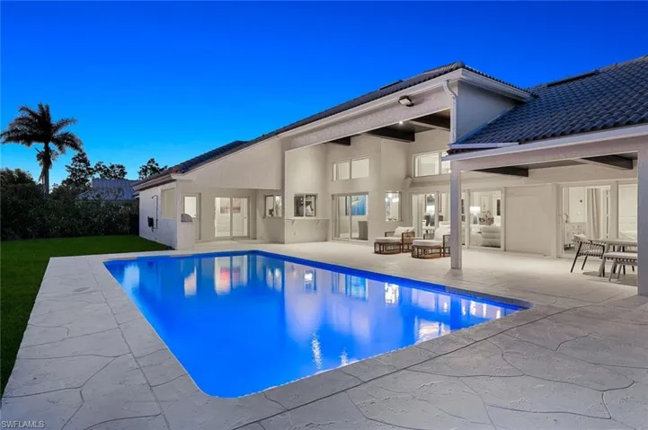 Rear view of property featuring a patio, stucco siding, and a tiled roof