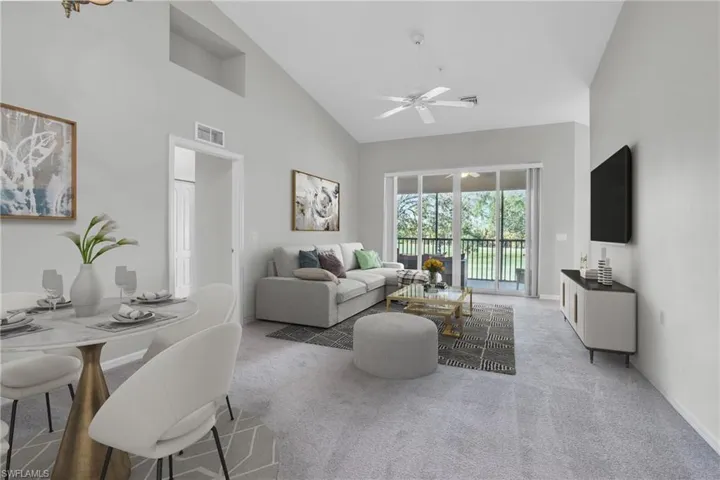 Living room featuring high vaulted ceiling, ceiling fan, and carpet flooring