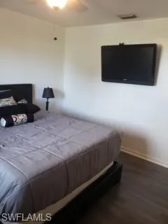 Bedroom with ceiling fan and dark hardwood / wood-style flooring