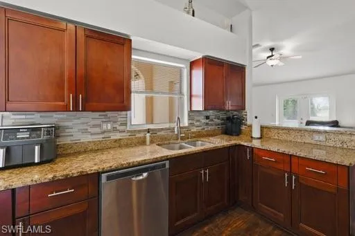 Kitchen featuring dark hardwood / wood-style flooring, stainless steel dishwasher, backsplash, sink, and ceiling fan