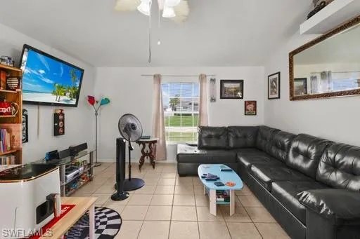 Living room featuring ceiling fan and light tile floors