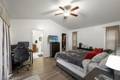 Bedroom with hardwood / wood-style floors, ensuite bath, ceiling fan, and lofted ceiling
