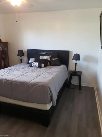 Bedroom with dark wood-type flooring and ceiling fan