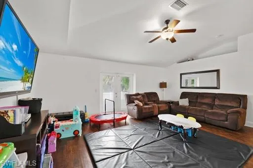 Living room featuring french doors, wood-type flooring, ceiling fan, and vaulted ceiling