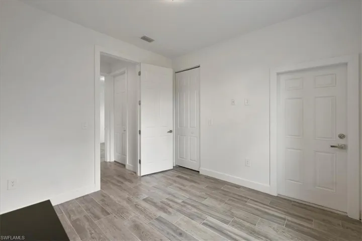Unfurnished bedroom with light wood-style flooring, baseboards, and a closet