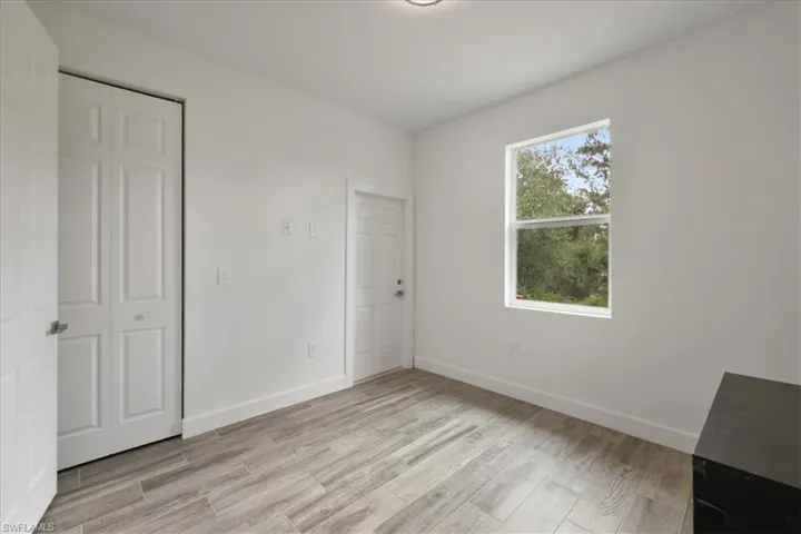 Unfurnished bedroom featuring light wood finished floors, baseboards, and a closet