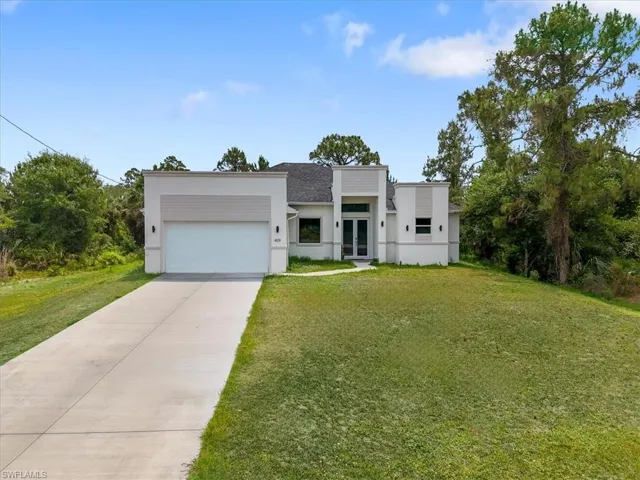 Modern home with french doors, stucco siding, an attached garage, and concrete driveway