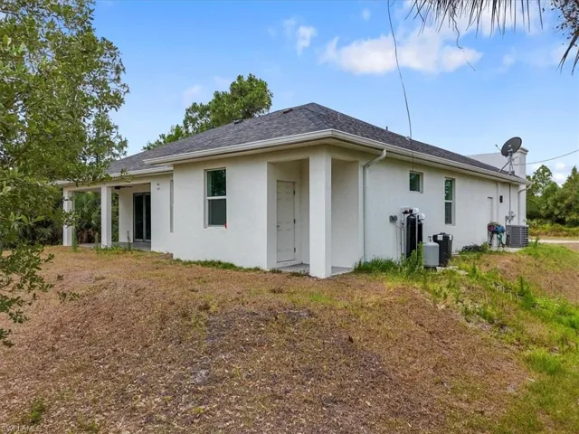 Back of property featuring stucco siding, central AC, and a shingled roof