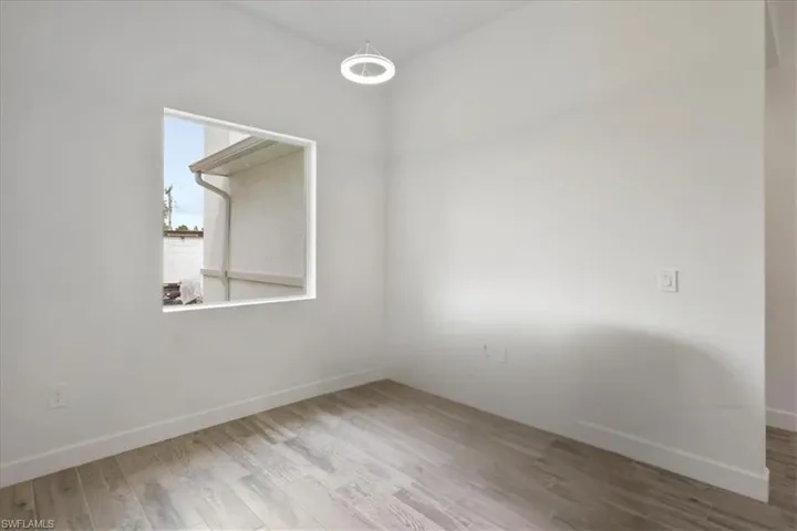 Unfurnished room featuring wood finished floors and baseboards