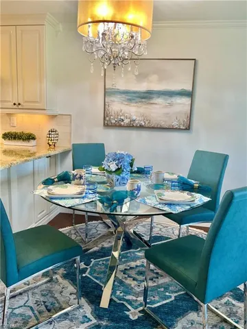 Dining space with crown molding and a notable chandelier
