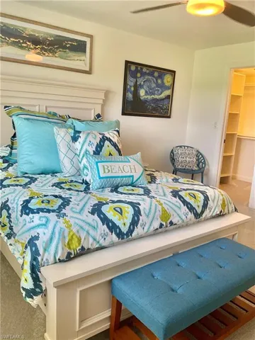 Carpeted bedroom featuring a closet, ceiling fan, and a walk in closet