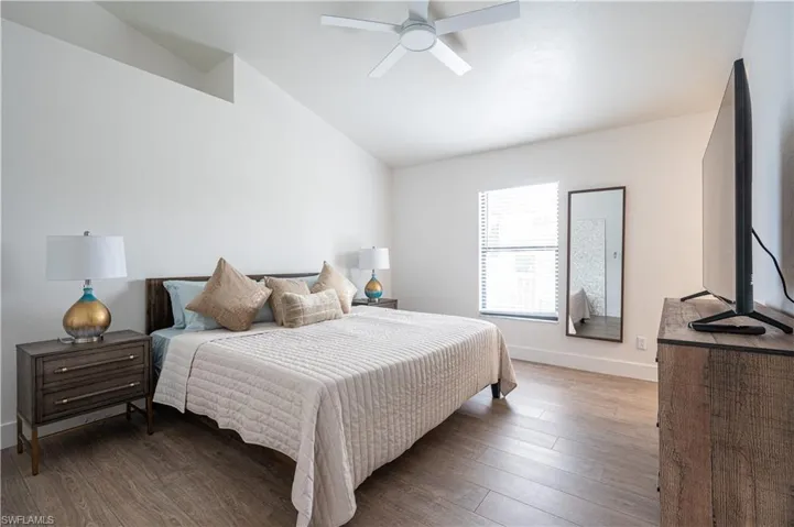 Bedroom featuring vaulted ceiling, ceiling fan, and dark wood-type flooring