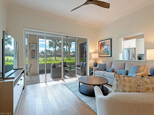 Living room with light wood-type flooring, ceiling fan, and crown molding