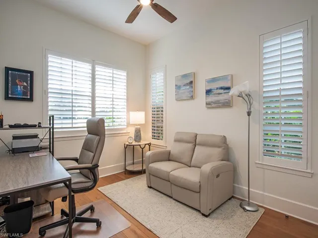 Home office with hardwood / wood-style floors and ceiling fan