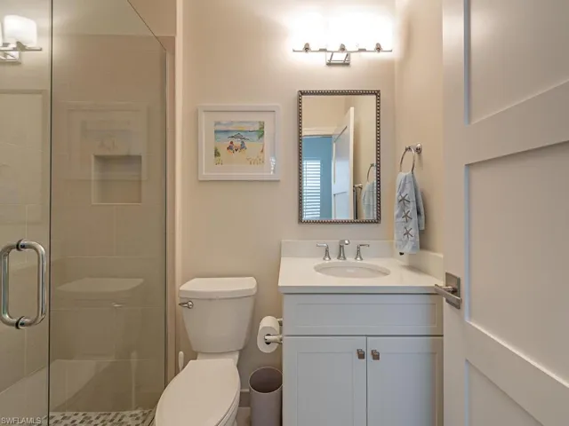 Bathroom with vanity, toilet, and an enclosed shower