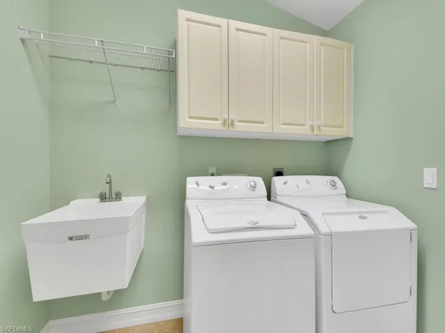 Laundry room with cabinets, sink, and washing machine and dryer