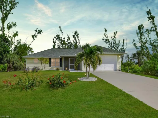 Single story home featuring a front yard and a garage