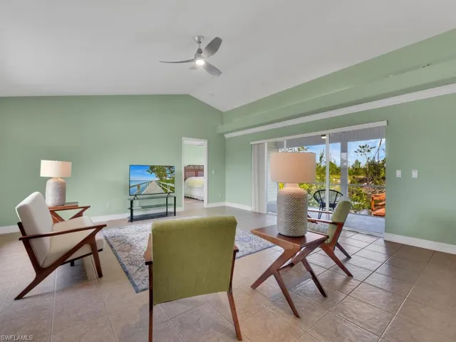 Tiled dining room with ceiling fan and lofted ceiling