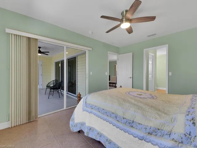 Tiled bedroom featuring ceiling fan