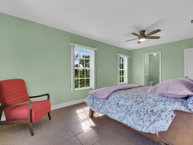 Tiled bedroom featuring ceiling fan