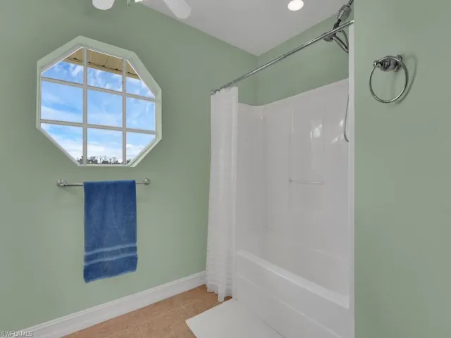 Bathroom featuring tile patterned floors and shower / tub combo with curtain