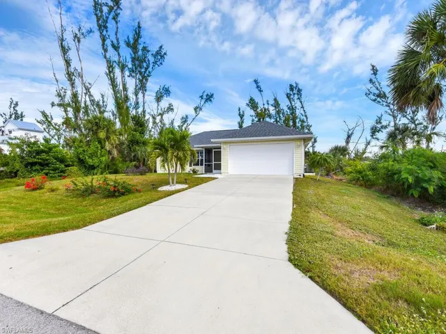Ranch-style house featuring a front lawn and a garage
