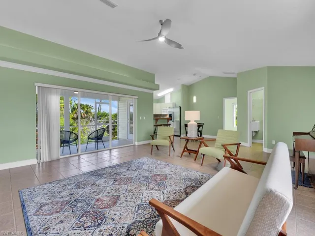 Tiled living room with vaulted ceiling and ceiling fan