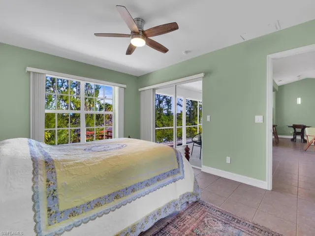 Tiled bedroom with access to exterior and ceiling fan