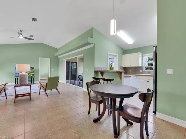 Tiled dining space featuring ceiling fan and vaulted ceiling