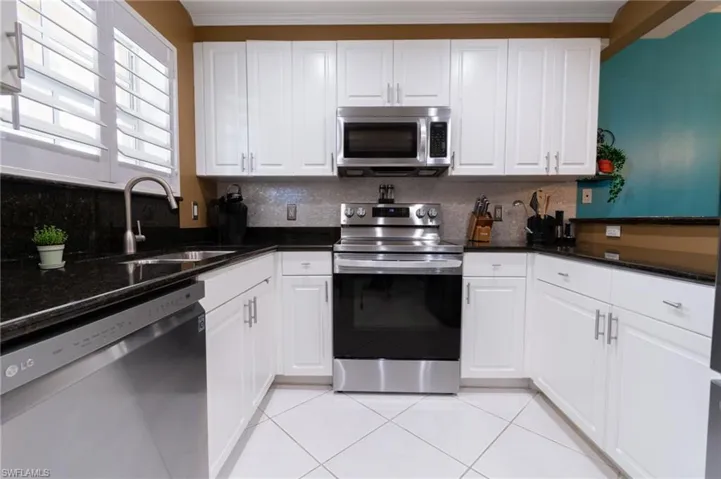 Kitchen featuring stainless steel appliances and white cabinets