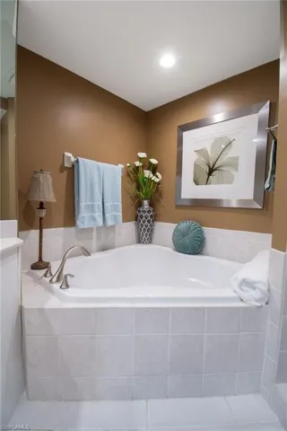 Full bathroom featuring vanity, tile patterned flooring, and a garden tub