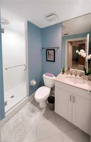 Bathroom with vanity, a shower stall, and light tile patterned flooring