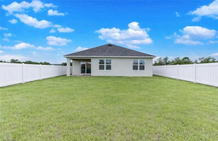 Rear view of property featuring stucco siding, a fenced backyard, and a patio area