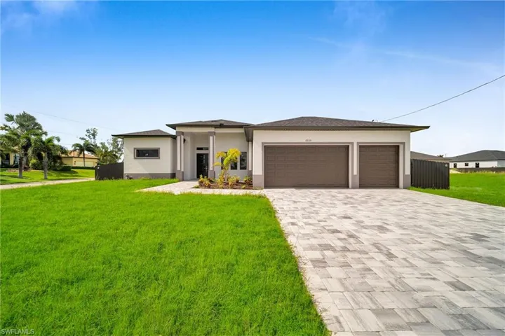 View of front of house featuring a front lawn and a garage