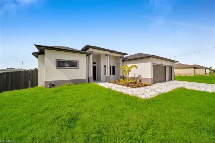 View of front of house with a front yard and a garage