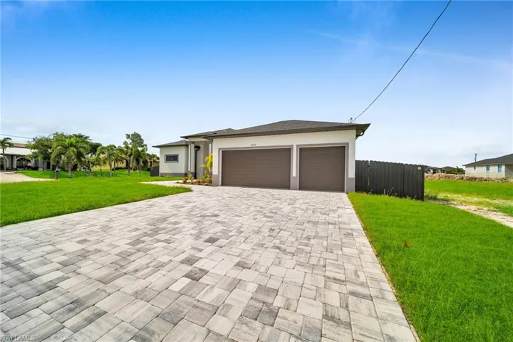 View of front of home featuring a front yard and a garage