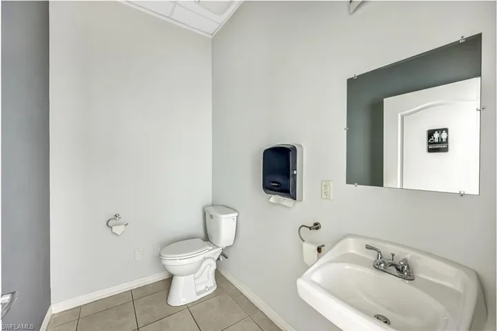 Suite 2 Half bath featuring toilet and light tile patterned flooring