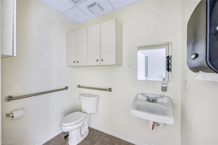 Suite 2 Bathroom with dark tile patterned floors and a drop ceiling