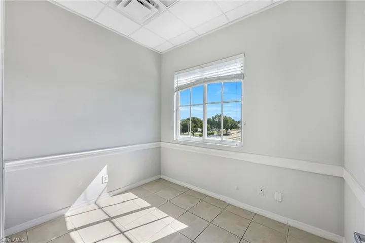 Suite 1- room with light tile patterned floors and a drop ceiling