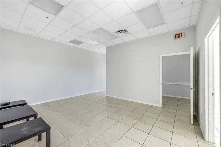 Suite 1Empty room with a paneled ceiling and light tile patterned flooring