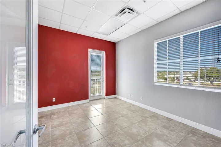 Suite 2 Spare room featuring healthy amount of natural light, a paneled ceiling, and light tile patterned floors